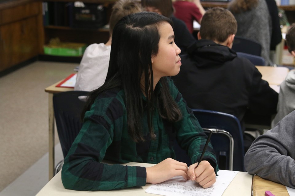 Grade 7 student, Kim Lai, works on her letter to pen pal, Em, in Toulouse, France. 