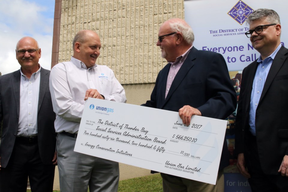 Tim Page (left), Nick Klip, Bob Katajamaki, and Bill Bradica shake hands on a project to bring efficient energy to 15 local affordable housing complexes. (Michael Charlebois, tbnewswatch).