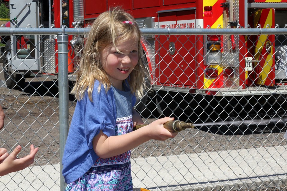 Mallory Levanen, 8,  tests out her fire suppression skills at Holy Family School on Monday, June 12, 2017 (Leith Dunick, tbnewswatch.com)