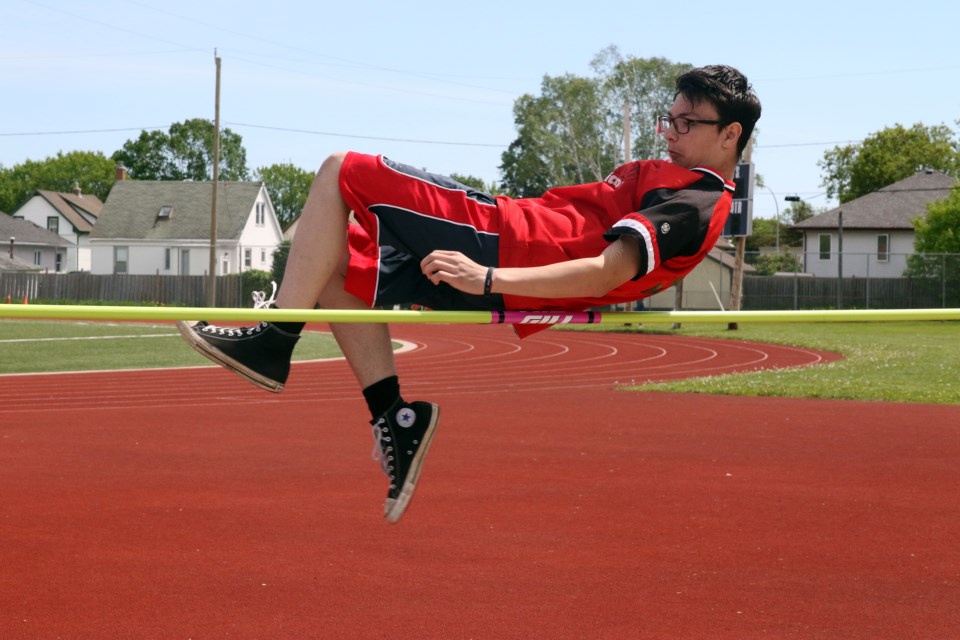 An Algonquin high school high jumper goes up and over at high jump.