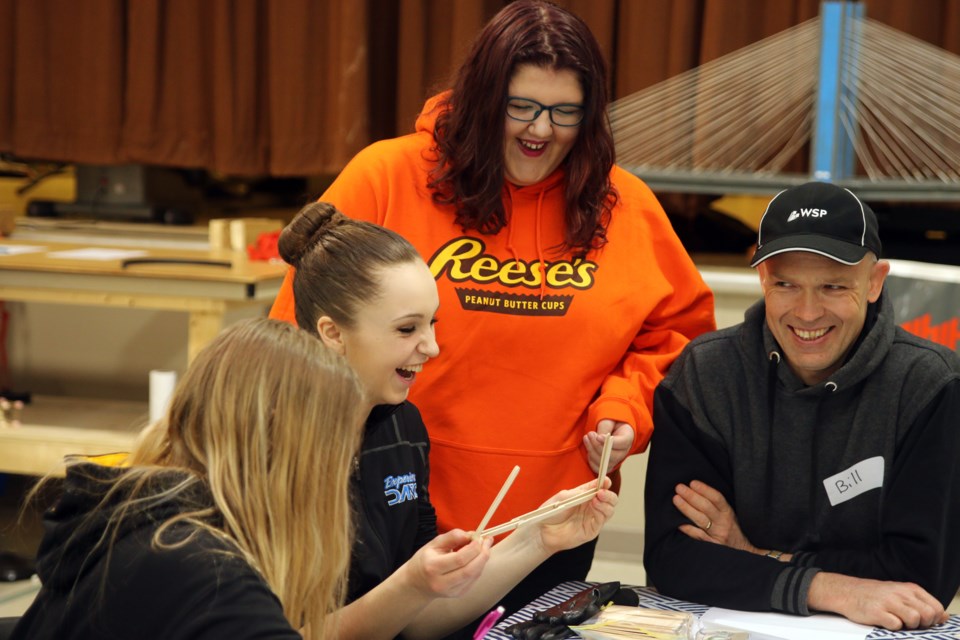 Grace Dawson (centre) and Emma Haliuk (right) try out a bridge design during National Engineering Month at Nordmin Engineering. 