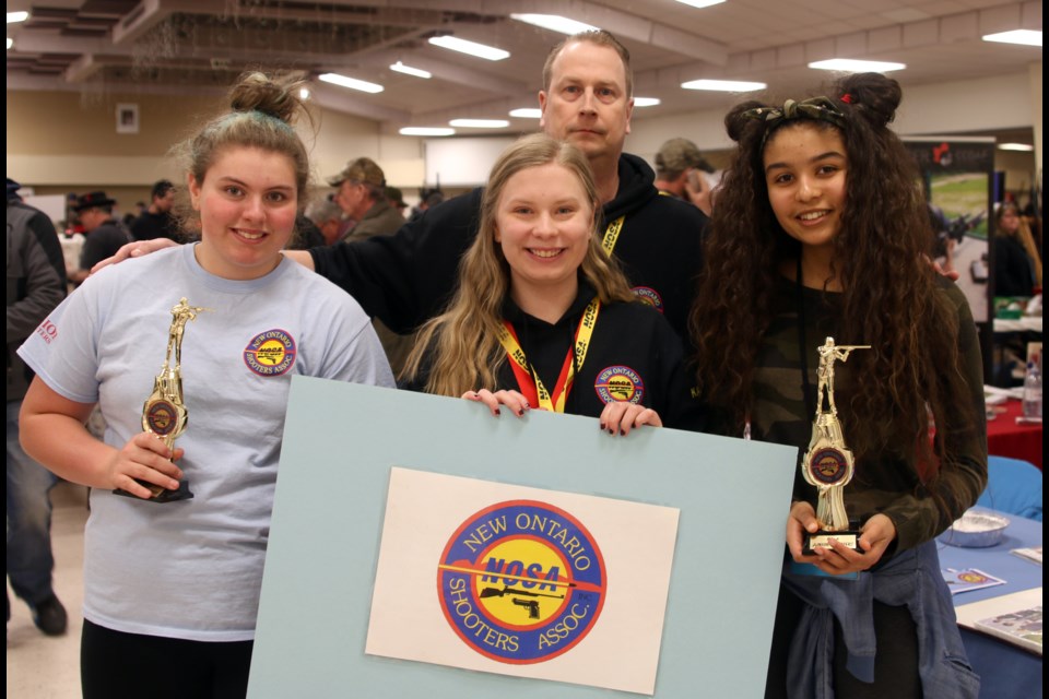 Members of the junior shooters club with the New Ontario Shooters Association show off some of their trophies from past shooting competitions. From left to right: Jordan Gale Richards, Kayla Levata, and Cassidy Jacobson with junior shooter lead coordinator, Dave Levata. 