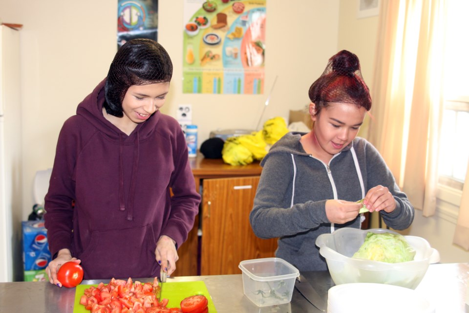 Leila Nattinen and Michelle King, members of the Vale/Limbrick Youth Council, were busy getting things ready on Saturday for the Indian taco and bannock burger fundraiser organized by the Vale/Limbrick Community Action Group. 