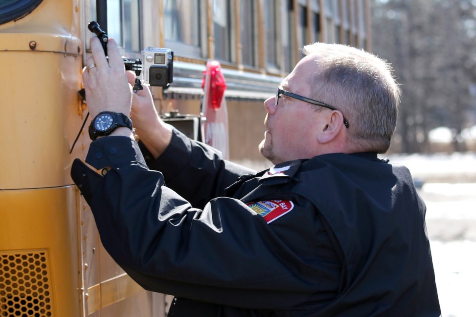 Acting traffic Sgt. John Toneguzzi installs a Go Pro camera on a Student First school bus on Tuesday, March 21, 2017 in Thunder Bay (Leith Dunick, tbnewswatch.com). 