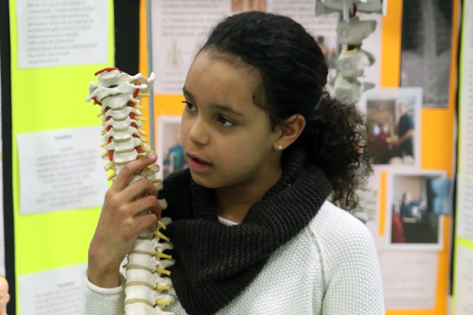 Tanika Payne, 9, demonstrates spinal health to students on Friday, March 24, 2017 at Ecole Catholique Franco Superiur during her school's science fair (Leith Dunick, tbnewswatch.com). 