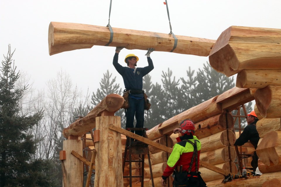Brad Pajamaki of Erickson Contracting guides a log into place during the construction of a log home in Neebing with the guidance of Peter Arnold of the HGTV series, Timber Kings. 
