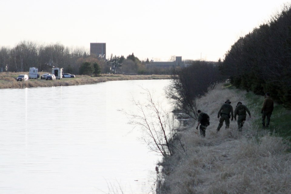 Officers search the north bank of the McIntyre River after the OPP's underwater search and recovery unit found a body in the river on Thursday. (Matt Vis, tbnewswatch.com)