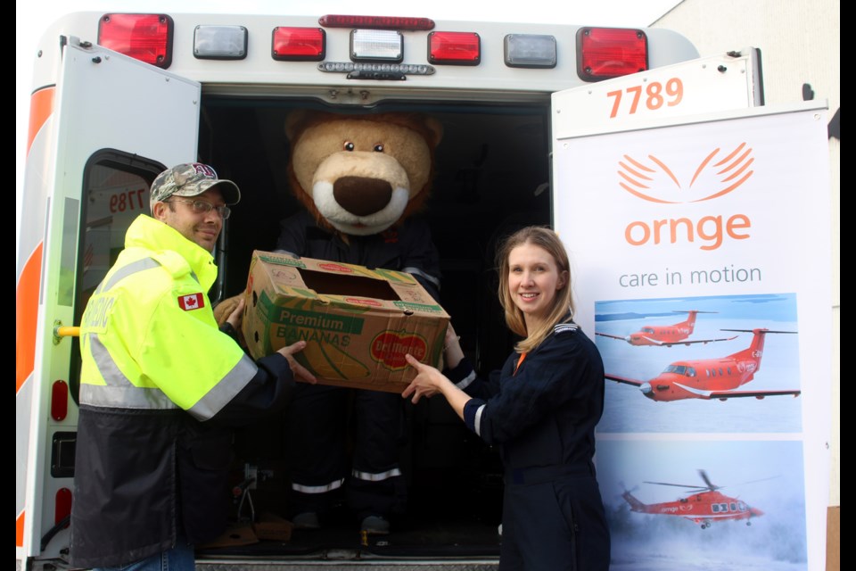 Daryl Parfeniuk (left) and Tegan Fletcher (right), paramedics with Ornge, help load an ambulance with food donations in support of the Regional Food Distribution Association during the Fill an Ambulance Food Drive. 
