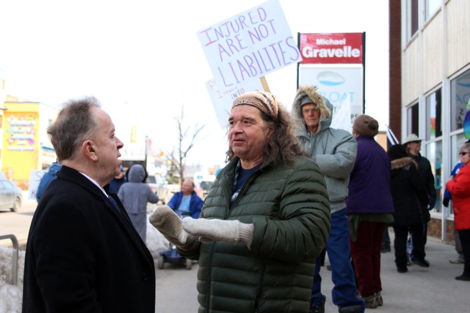 MPP Michael Gravelle speaks with Thunder Bay and District Injured Workers Support Group president, Eugene Lefrancois during an injured workers rally on Tuesday.  