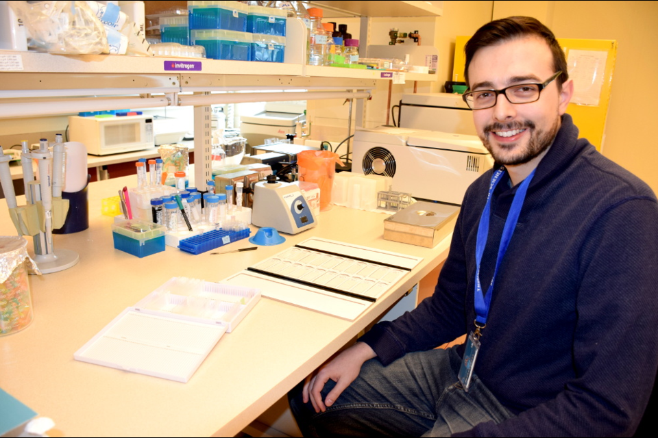 Robert Jackson describes the different layers of skin in the sample he grew, which is under the microscope. Jackson is researching HPV at the Thunder Bay Regional Health Sciences Institute. (Photo courtesy of Lakehead University)