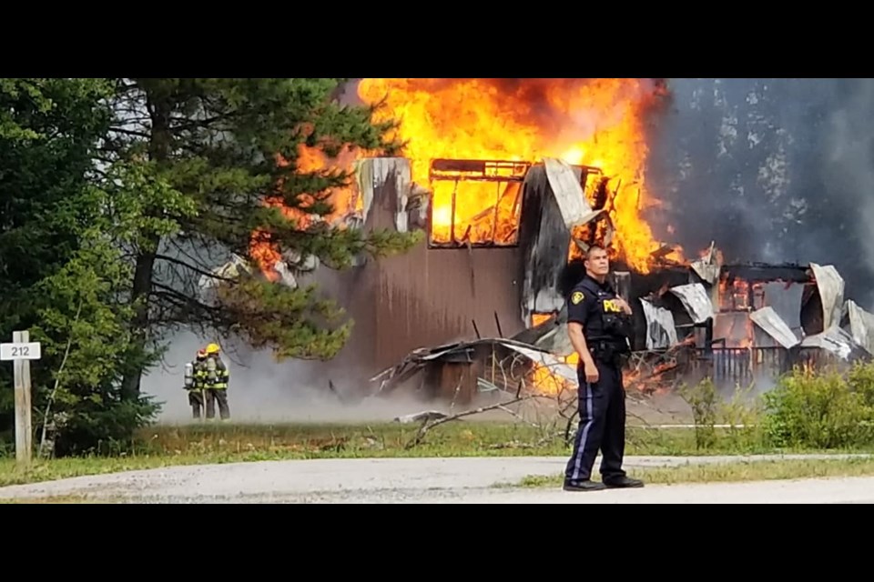 An OPP officer controls traffic near Sunday's fire outside Dryden (Photo courtesy Sharon Girdwood)