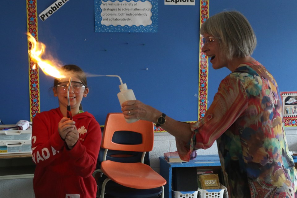 Samantha Bradley (left) and Patyy Hajdu light a flame at Science North summer camp at Vance Chapman Public School. (Michael Charlebois, tbnewswatch)