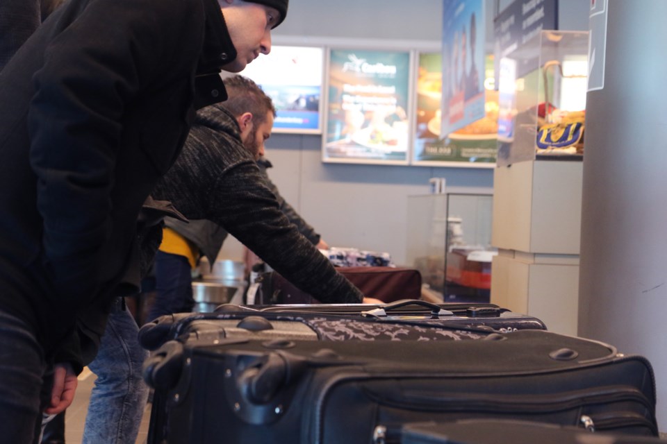 Travelers grab their bags at the Thunder Bay International Airport. (Michael Charlebois, tbneswatch)
