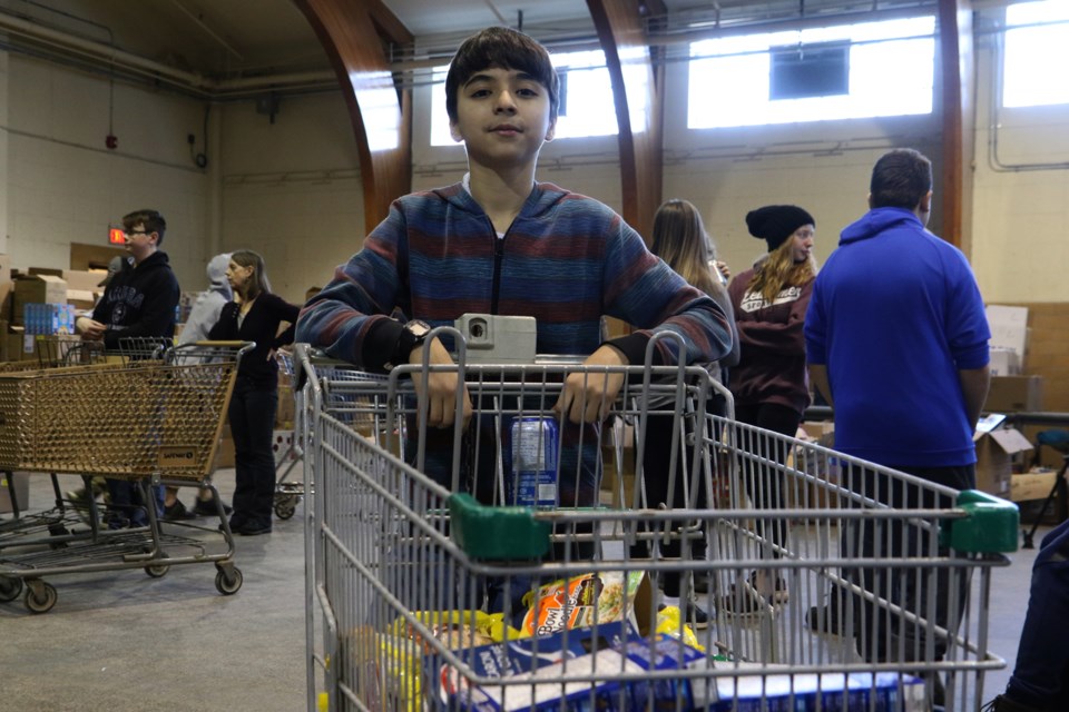 Nasr Alahmar of Ecole Gran Morgan Public School with his cart of non-perishable food items. (Michael Charlebois / tbnewswatch)