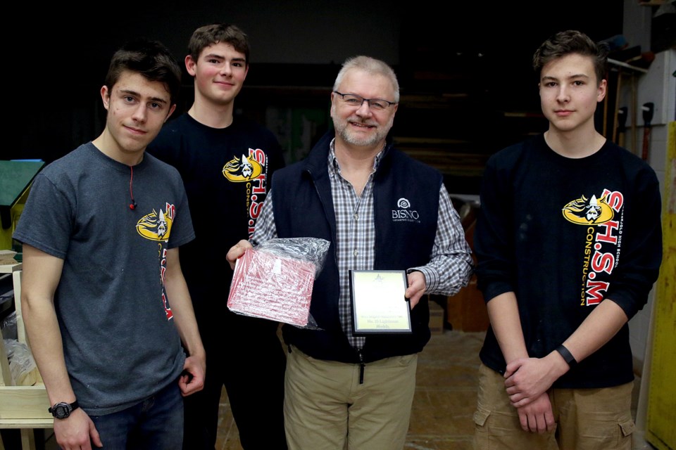 Hammarskjold High School students Andrew Chambers, Alec Picard and Taedj Pelechaty are give a plaque by Canadian Lighthouses of Lake Superior's Paul Capon on Wednesday, Dec. 19, 2018. (Leith Dunick, tbnewswatch.com)