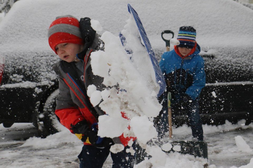 Ethan (left) and Gavin Grant help their father out with the driveway. (Michael Charlebois, tbnewswatch)