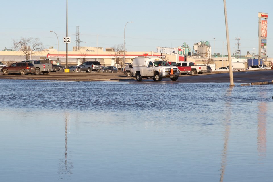 A city worker watches over a watermain break on Friday, Dec. 14, 2018 on Isabel Street, adjacent to Intercity Shopping Centre. (Leith Dunick, tbnewswatch.com)