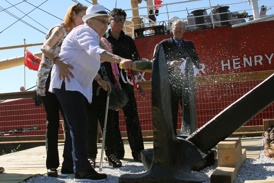 Annie Kolisnyk breaks a ceremonial champagne bottle to officially rededicate the Alexander Henry on Wednesday, July 18, 2018. (Matt Vis, tbnewswatch.com)