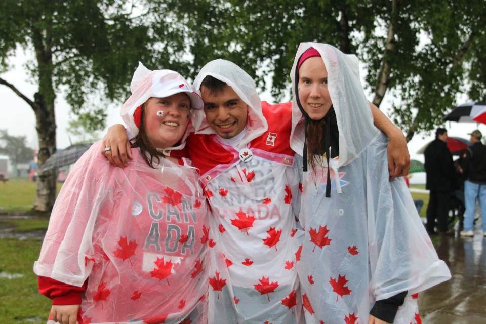 Kyle Boyce (middle), along with friends Katie Olsen and Karli Doust, braved the rain to celebrate Canada Day at Marina Park before festivities were cancelled due to rain. (Photos by Doug Diaczuk - Tbnewswatch.com). 