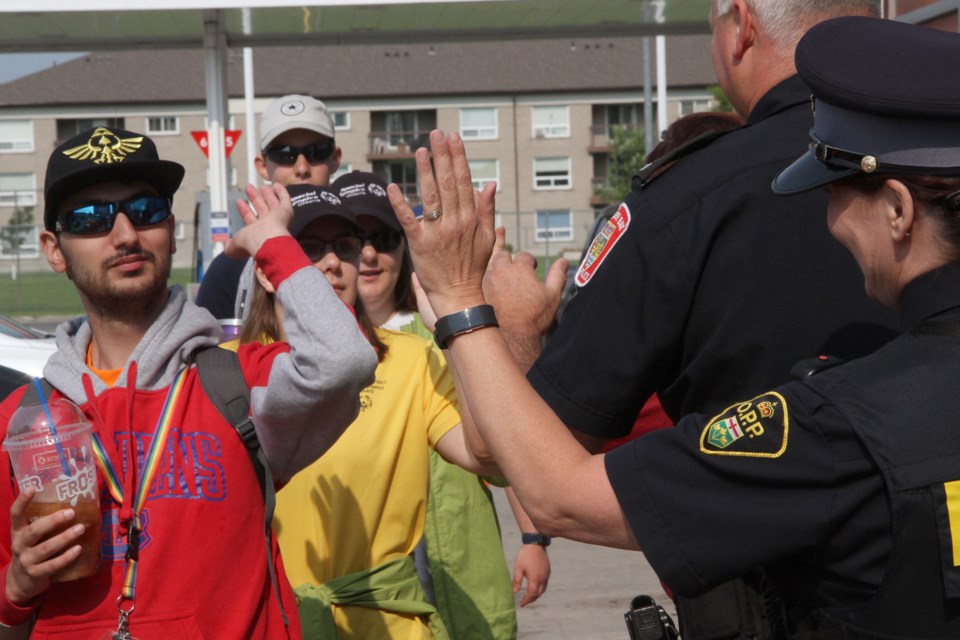Edwin McCauley hi-fives local enforcement officers at the Mac's Convenience store. (Michael Charlebois / tbnewswatch)