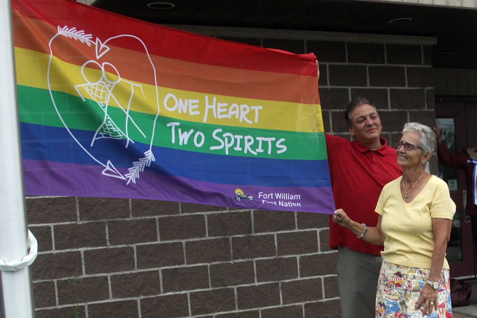 Flag designer Lorraine Bannon and community member Raili Saarinen display the pride flag recognizing the two-spirited community that was raised outside the Fort William First Nation office on Wednesday, July 11, 2018. (Matt Vis, tbnewswatch.com)