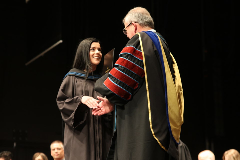 Jayden Miranda accepting her diploma from president Jim Madder on Friday, June 8. (Michael Charlebois, tbnewswatch.com)