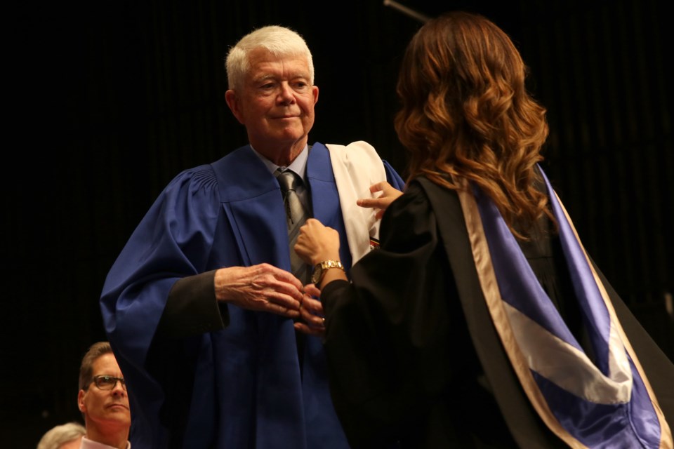 Jim Symington receives his blue gown after being nominated into Lakehead Univeristy's fellowship. (Michael Charlebois / tbnewswatch)