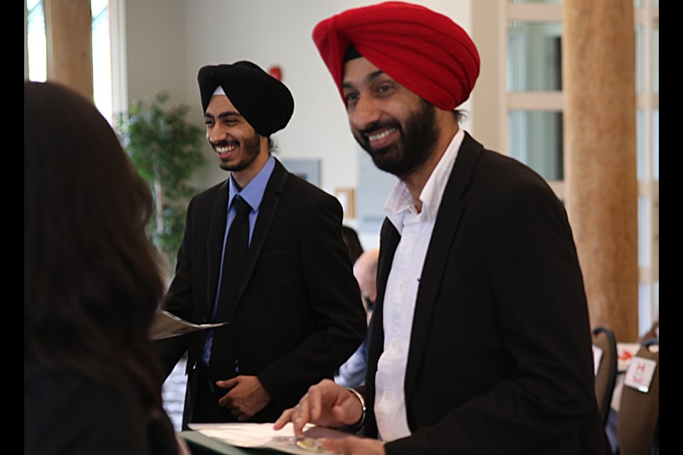 Yamandeep Malhi (left), and his father Satinderjit, receiving their citizenship papers at Fort William Historical Park on Thursday. (Michael Charlebois / tbnewswatch)