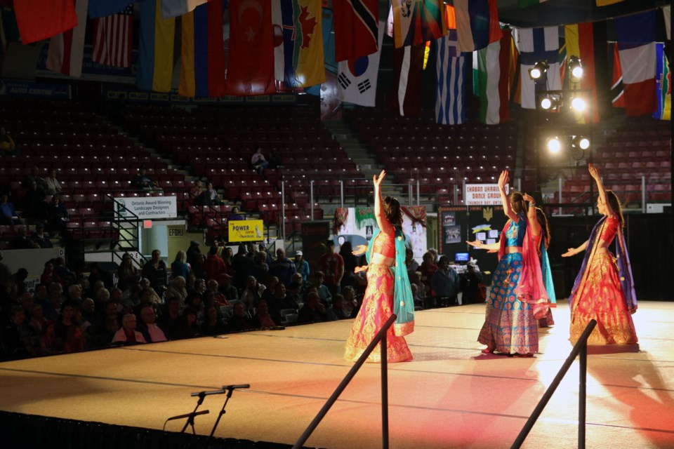 A crowd looks on the stage at Fort William Gardens  with the flags of the world hanging overhead.  (Michael Charlebois / tbnewswatch)