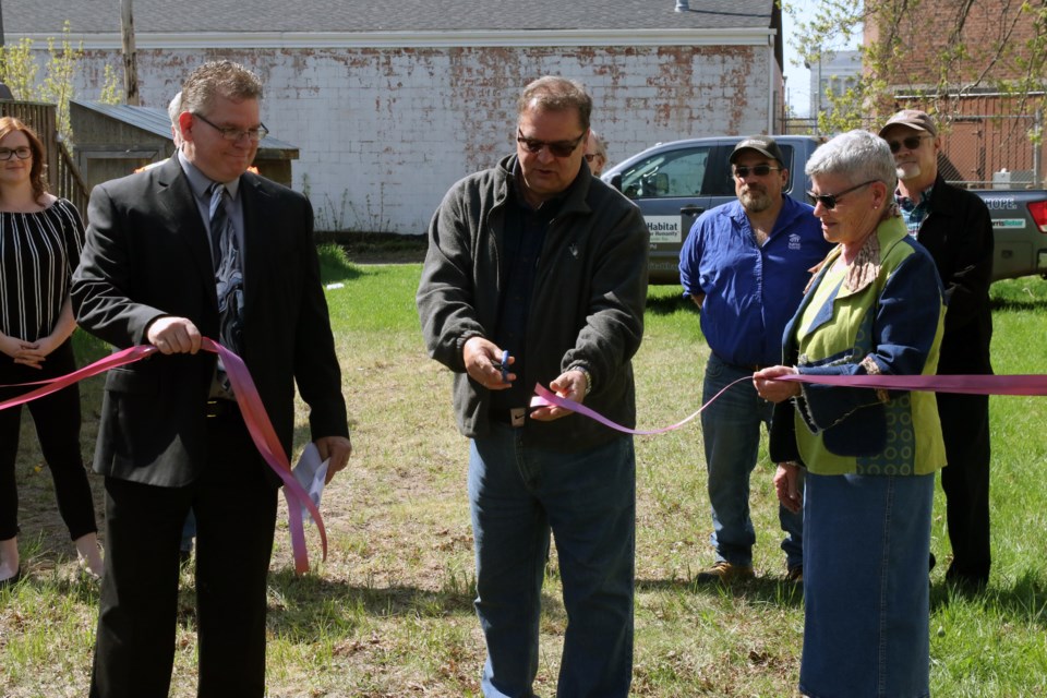 Habitat for Humanity CEO Randy Moore (left), committee member Harold Lindstrom, and Coun. Rebecca Johnson, unveil a new property on Leith Street. (Michael Charlebois, tbnewswatch) 