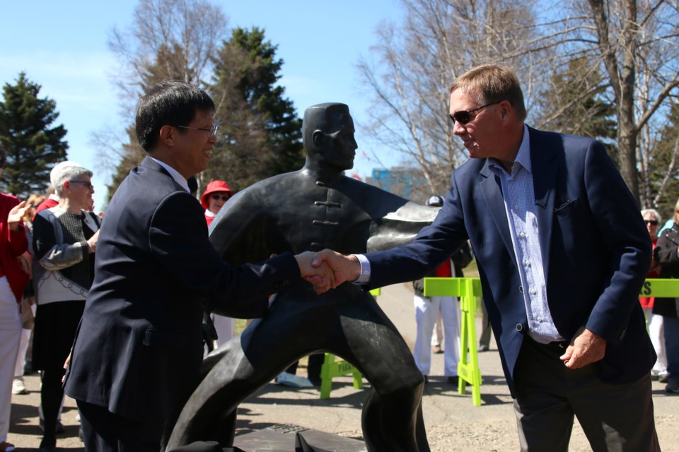 Brian McKinnon, then-chair of Thunder Bay's sister cities committee, thanks Jiaozuo City mayor Xu Yixian in 2018 for a donation of three statues that sit at the waterfront Tai Chi park. (File photo)