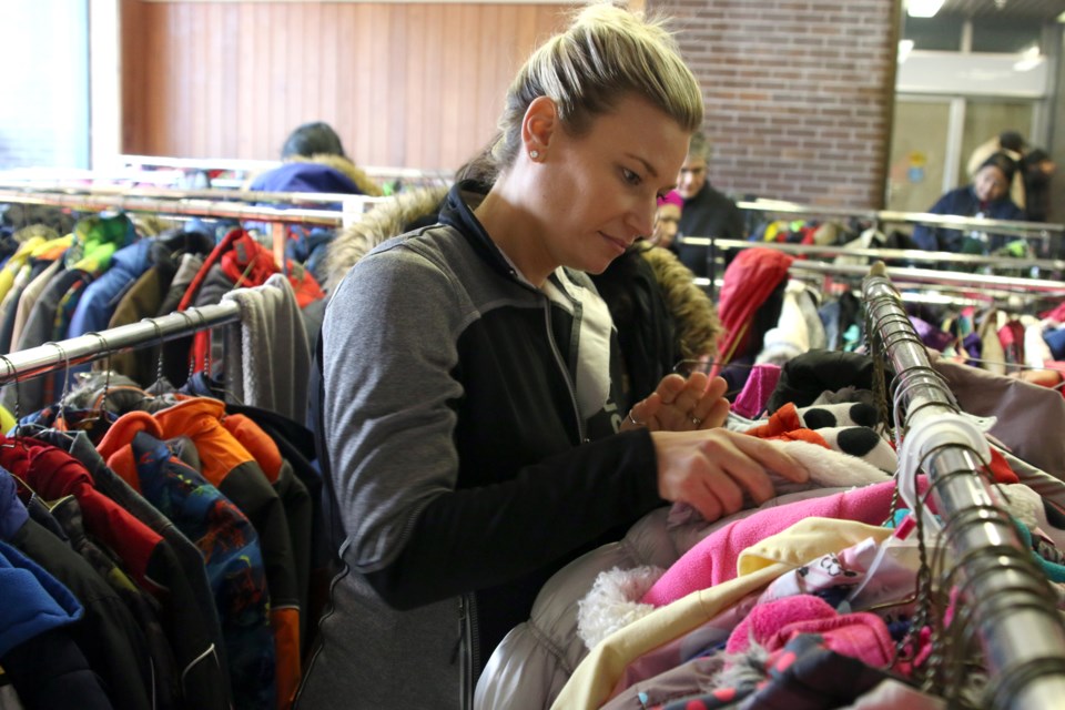 Volunteer Jacqui Workman helps sort through hundreds of coats donated to the Kids for Coats Giveaway on Saturday. (Photos by Doug Diaczuk - Tbnewswatch.com). 