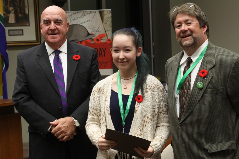 Rahne Mehagan (centre) receives her Mayor's Community Safety Award from Thunder Bay mayor Keith Hobbs and Crime Prevention Council chair Jeff Upton at Thunder Bay city hall on Monday, November 5, 2018. (Matt Vis, tbnewswatch.com)