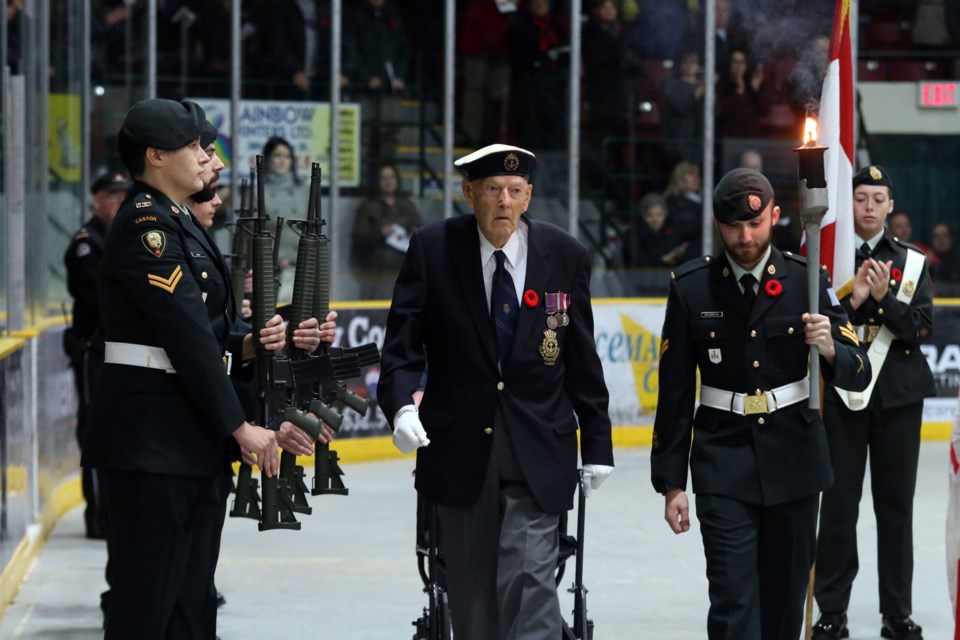 Mo Nelson (left), a veteran of the Second World War, passed the torch to MCpl. DesJardins during the Remembrance Day Ceremony at the Fort William Gardens on Sunday. (Photos by Doug Diaczuk - Tbnewswatch.com). 