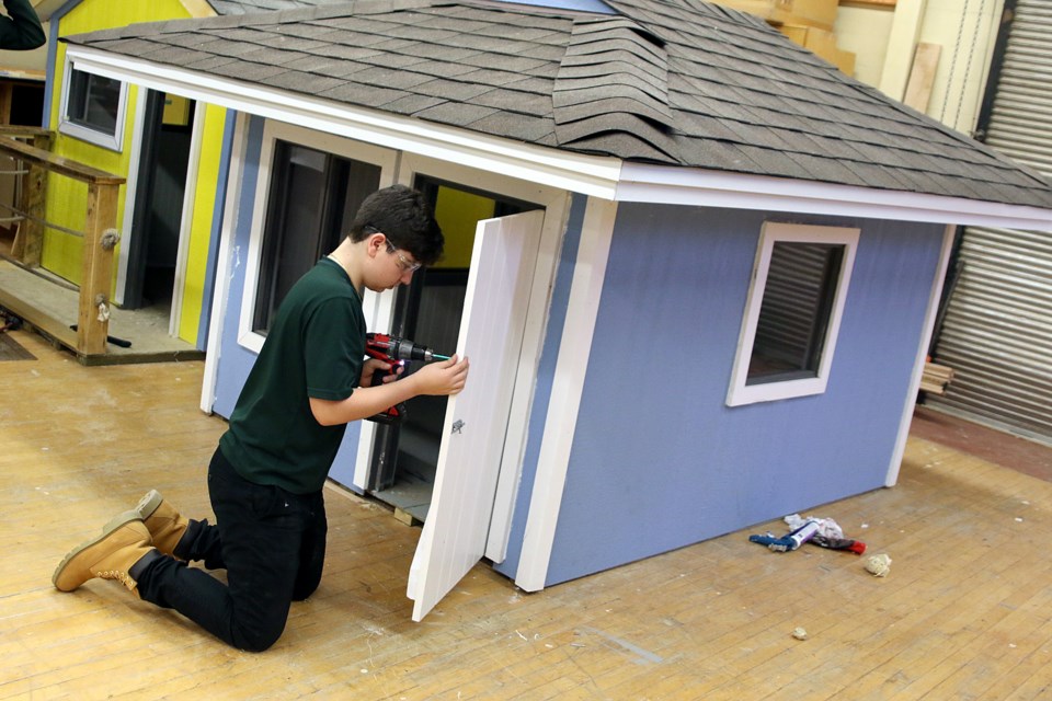 St. Patrick High School Grade 11 student Josh Bisignano on Friday, Nov. 30, 2018 puts the finishing touches on a playhouse he and classmates built to donate to The Thunder Bay Children's Centre Foundation for an upcoming raffle. (Leith Dunick, tbnewswatch.com)