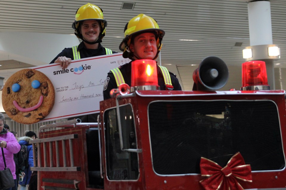 Firefighters Kari Rikkonen and Jay Gilbert go for a spin at the Intercity Shopping Centre during the Toys for Tots launch on Friday, November 16, 2018. (Matt Vis, tbnewswatch.com)