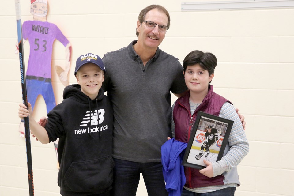 Griffin Dysievick (left) and Vivian Davenport, students at Holy Family School, on Wednesday, Oct. 31, 2018 celebrate Orange and Black Day with Robert Bortuzzo, father of NHLer Robert Bortuzzo, and a former teacher at the Rosslyn Road school. (Leith Dunick, tbnewswatch.com)