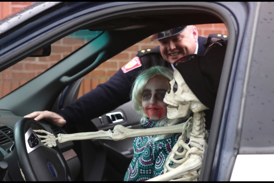 Melinna Lankimaki tries out the siren in a Thunder Bay Police Service vehicle along it Insp. Ryan Gibson and Officer Bones during the Thunder Bay Police Service Halloween Safety Display. (Photos by Doug Diaczuk - Tbnewswatch.com). 