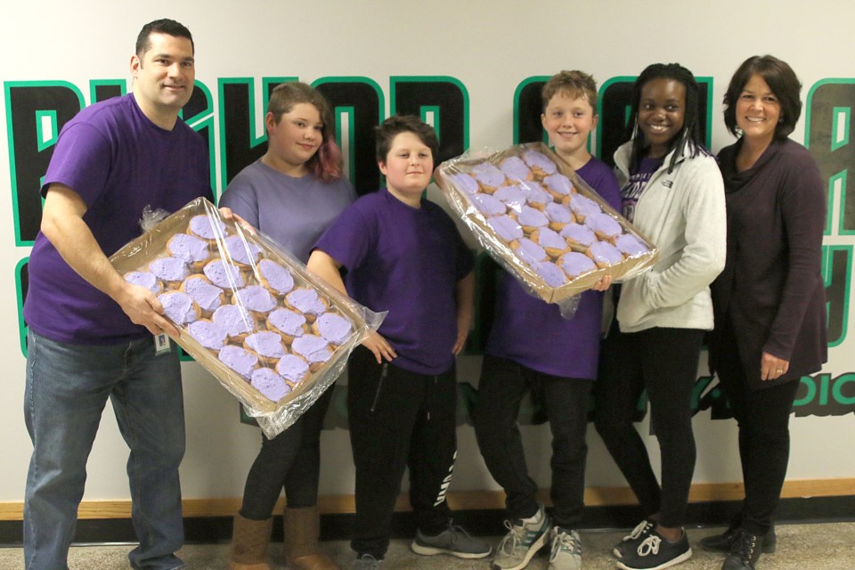 Bishop Gallagher School principal Ryan McWirter, Grade 7 students Ella Maki, Eli McWhirter, Thomas Hardie and Ayowunmi Adewuyi, and guidance counsellor Kristen Grillo, with purple-iced persions for sale in support of Beendigen, on Wednesday, Oct. 24, 2018. (Leith Dunick, tbnewswatch.com)