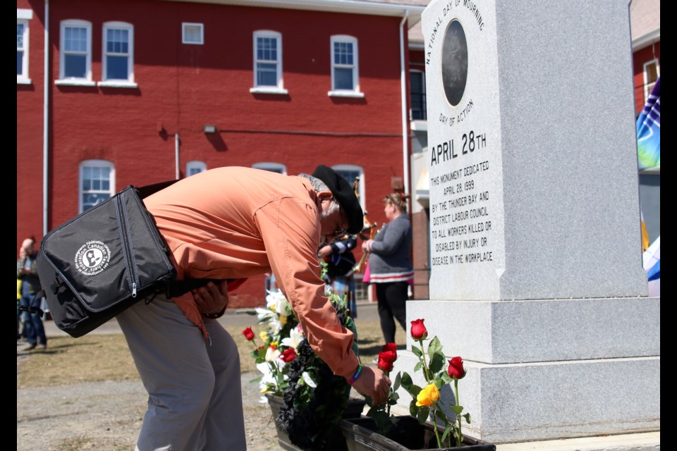 Carlos Santander-Maturana, president of the Thunder Bay and District Labour Council, places a flower at the monument dedicated to injured or killed workers outside the Finlandia Hall on Sunday. (Photos by Doug Diaczuk - Tbnewswatch.com). 
