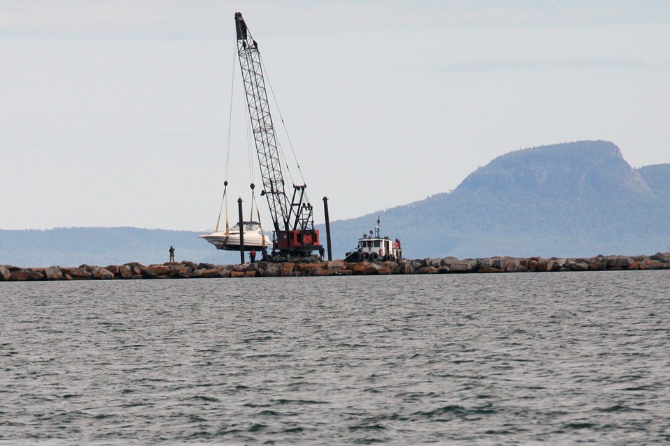 The boat that crashed into the harbour break wall is removed on Friday, August 23, 2019. (Matt Vis, tbnewswatch.com)