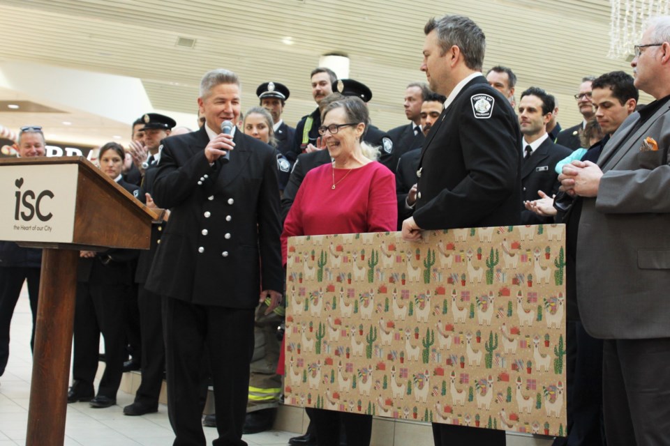 Toys for Tots chair Paul Penna, at left, and Christmas Cheer chair Jolene Kemp, centre, prepare to announce this year's fundraising total. (Photos by Ian Kaufman, Tbnewswatch) 