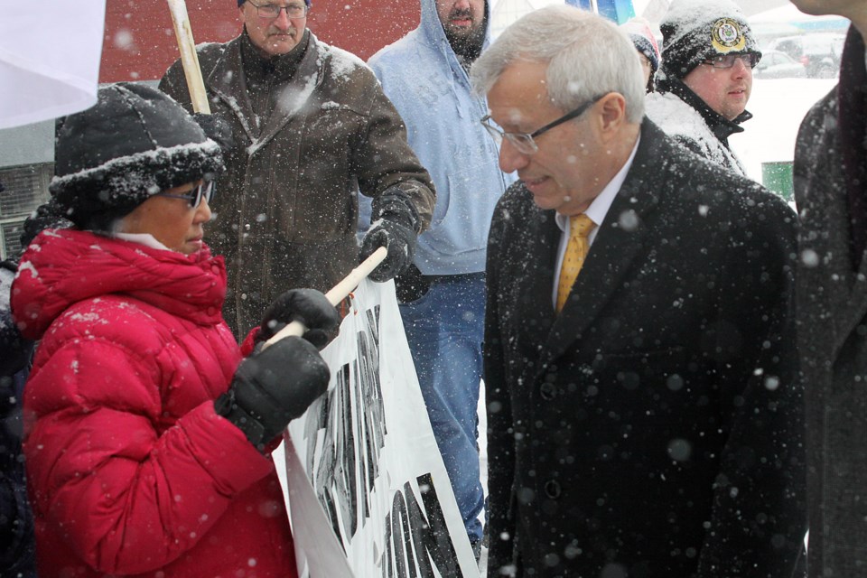 Ontario Finance Minister Vic Fedeli walks through a crowd of demonstrators while he makes his way to a public budget consultation session at the Finlandia Hall in Thunder Bay on Thursday, February 7, 2019. (Matt Vis, tbnewswatch.com)