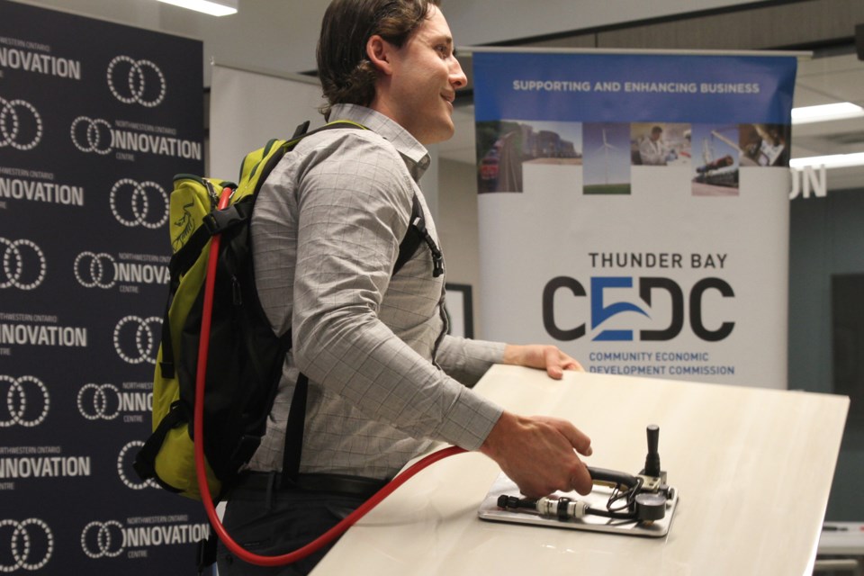 Conor Lyon, co-founder of Lynac Tile Equip., demonstrated some new tools at an event at the Northwestern Ontario Innovation Centre in July 2019 (Tbnewswatch file)