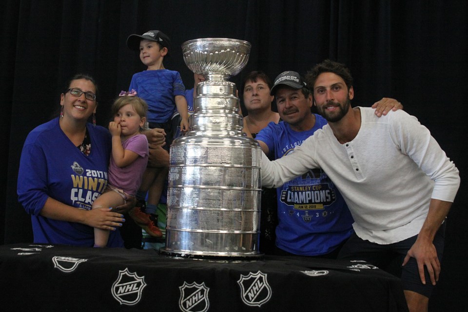 Long-time St. Louis Blues fan Wayne Parise (second from right) poses with Stanley Cup champion Robert Bortuzzo (right) and the Stanley Cup at a public meet-and-greet in Thunder Bay on Tuesday, July 16, 2019. (Matt Vis, tbnewswatch.com)