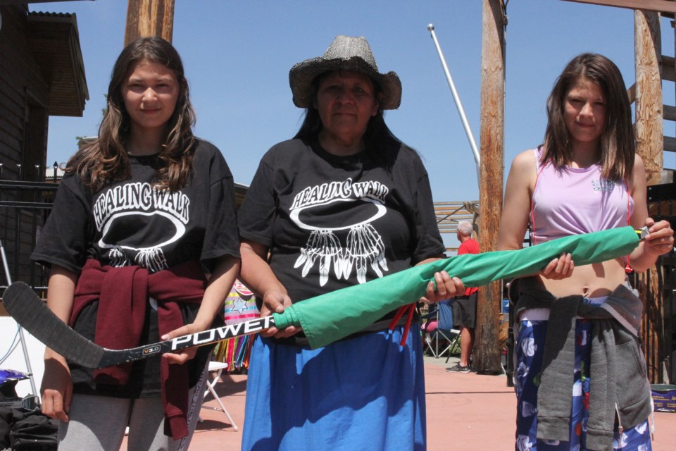 Dawn, Judy, and Ricki Whitehead holding the hockey stick of Daniel Whitehead in his memory. (Michael Charlebois, tbnewswatch)