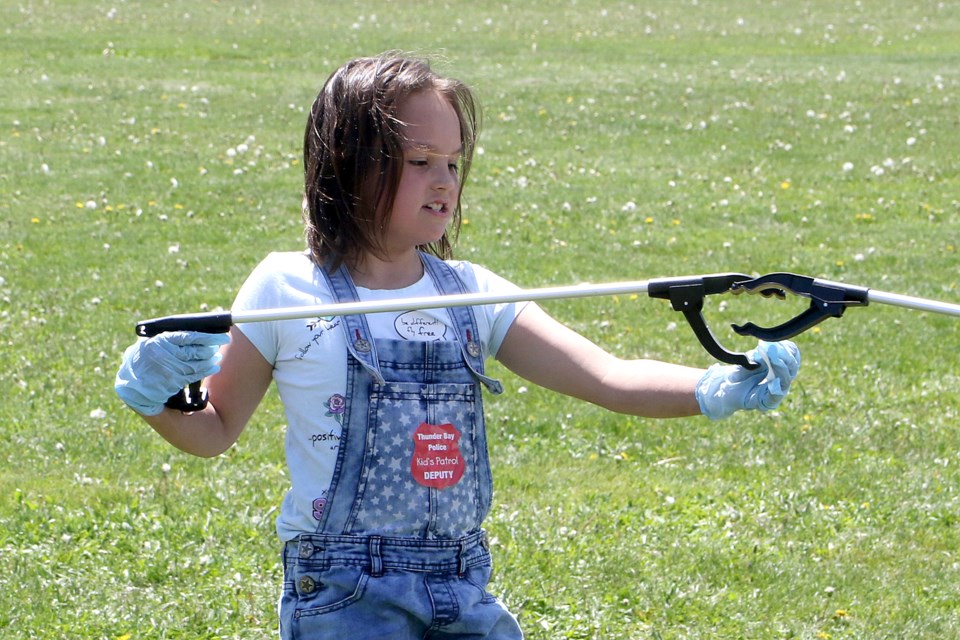 Aryana Hubbard-English, a Grade 2 students at McKellar Park School, helps clean up the school-yard on Thursday, June 20, 2019, launching the police-driven Project Footprint. (Leith Dunick, tbnewswatch.com)