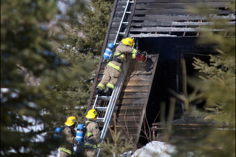 Thunder Bay Fire Rescue crews work to open up the roof of a Coppin Road residence after a structural fire was reported Monday afternoon. (Photos by Doug Diaczuk - Tbnewswatch.com). 