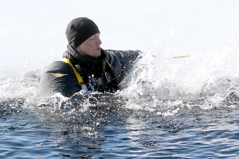 Tactical medic Troy Barnard on Friday, March 22, 2019 takes the plunge into Lake Superior to learn cold-water survival techniques. (Leith Dunick, tbnewswatch.com)