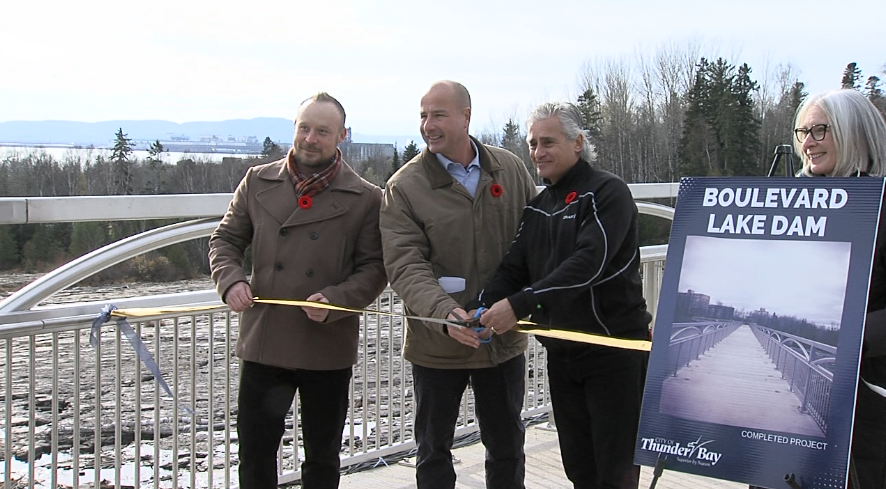 From left to right, project engineer Mike Vogrig, Councillor Andrew Foulds, Mayor Bill Mauro and MP Patty Hajdu participate in the ribbon-cutting at the rebuilt Boulevard Lake Dam on Nov. 10, 2021 (Alex Flood/TBTV News)